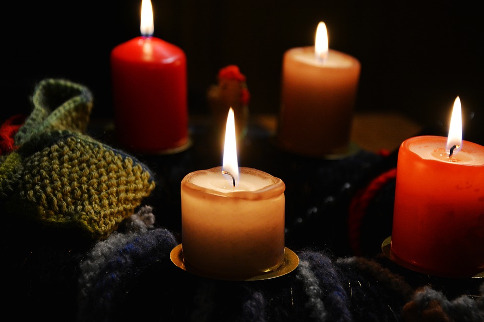 Image of lit red and yellow candles against dark background