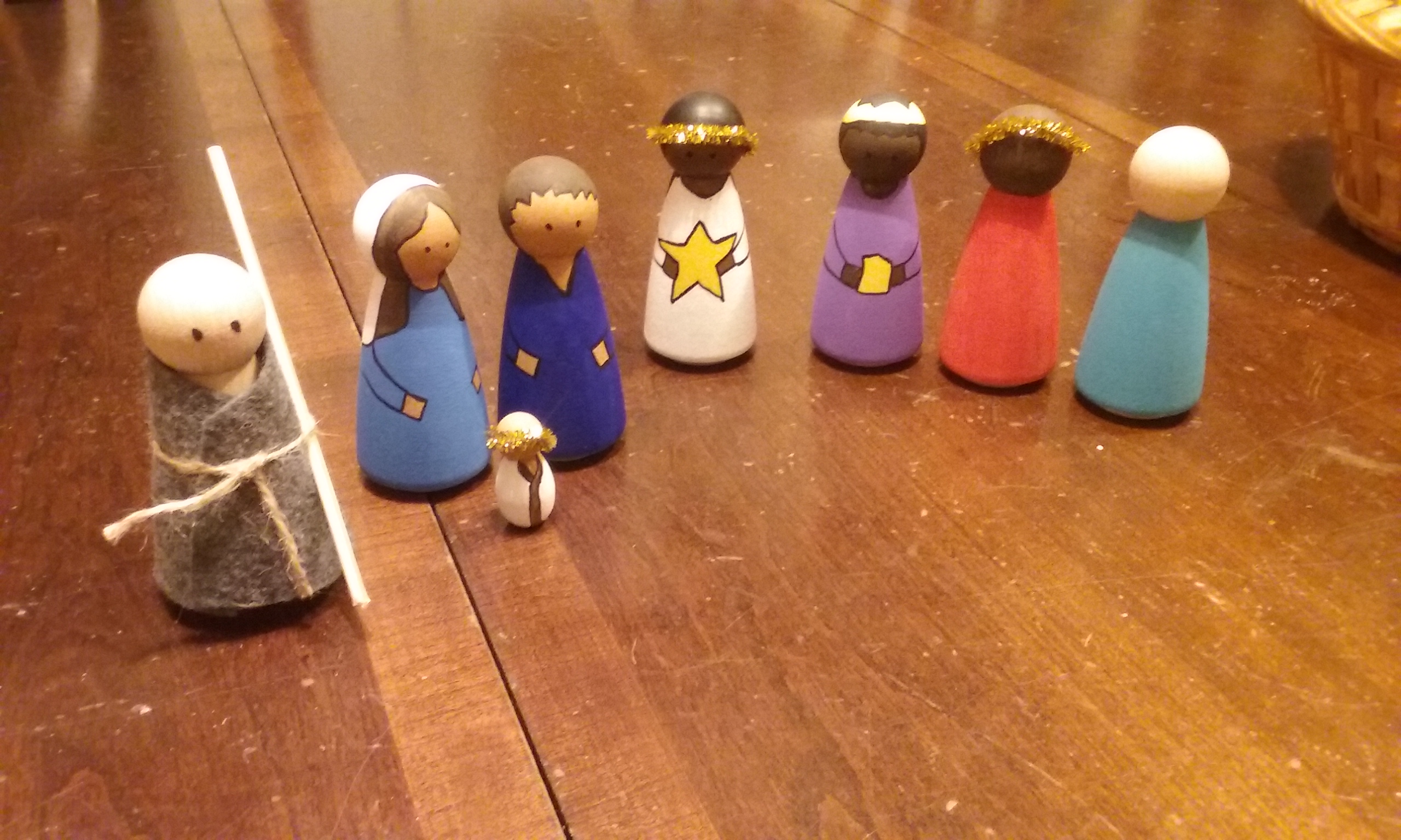 Image of eight wooden peg Nativity figures on a table.