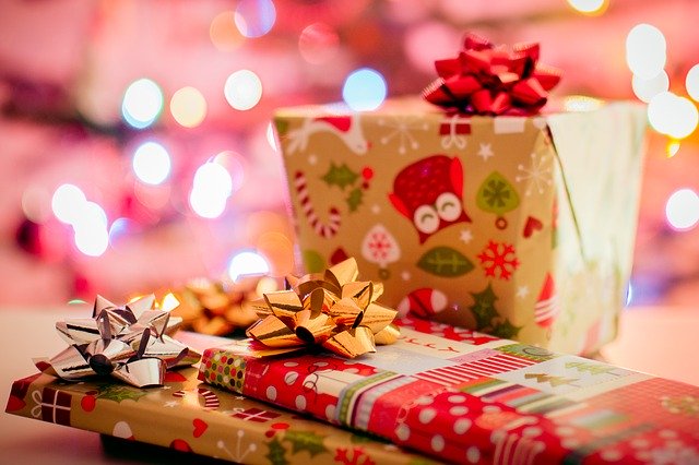 Image of wrapped Christmas presents in front of bright lights