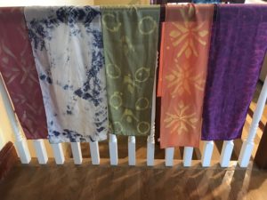 Photo of five colorful scarves hanging.