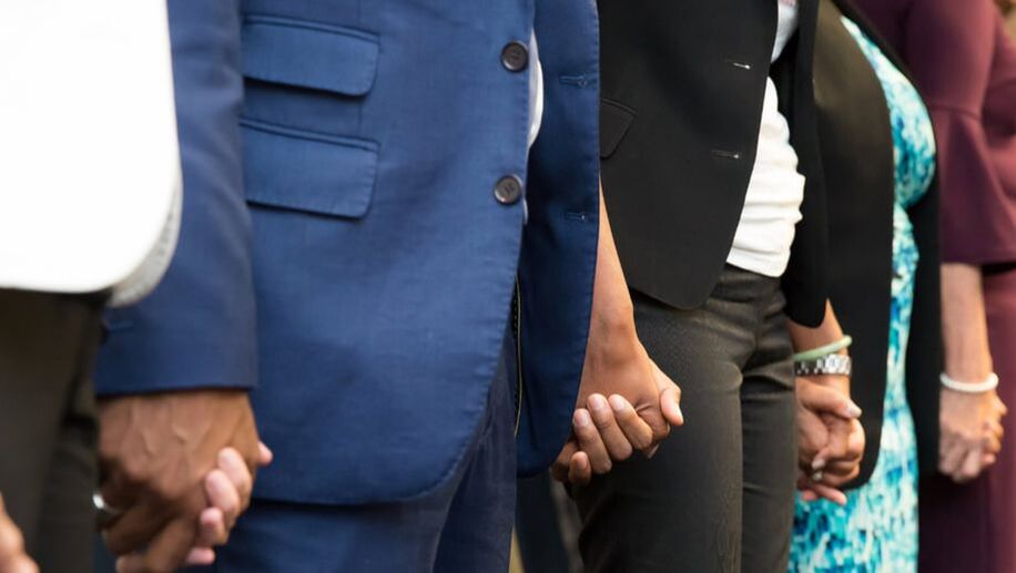 Image of close up of hands held in a line of people.