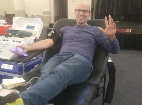 Photo of man reclined in chair next to blood donation equipement