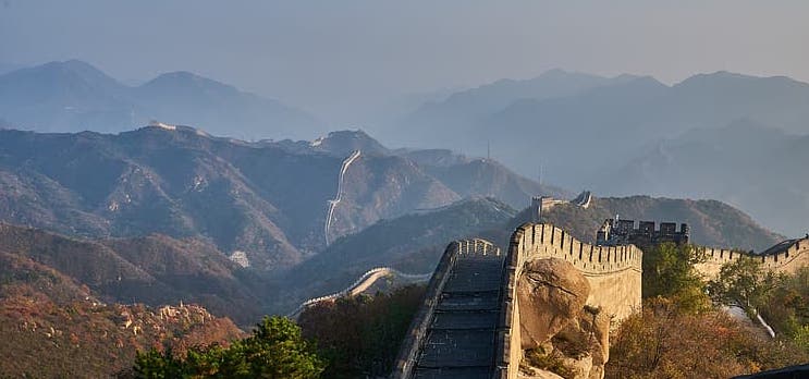 photo of Great Wall in foreground, mountains in distance